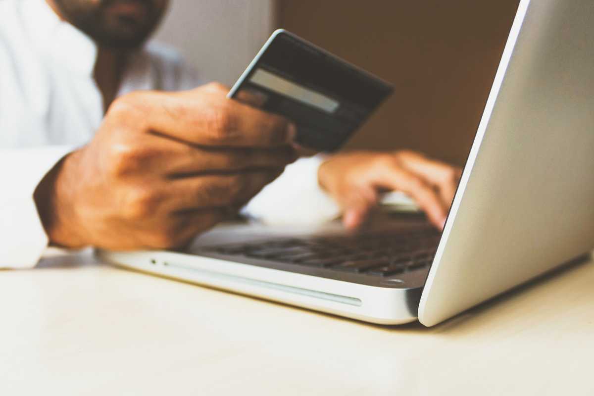 Man with card and laptop online shopping